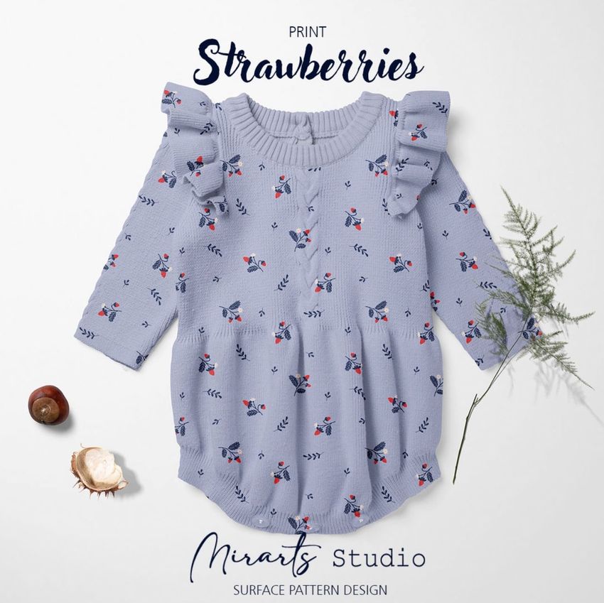 Knitted romper mockup featuring a light blue garment with a strawberry pattern, displayed flat with decorative leaves and nuts.
