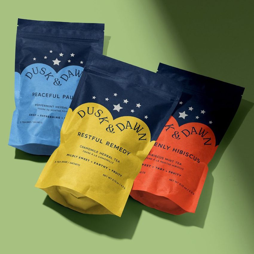 Stand up paper pouch mockup featuring three colorful pouches with star graphics and text, arranged on a green surface.