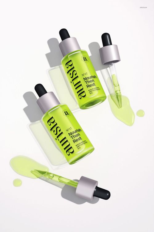 PSD mockup featuring two transparent green dropper bottles and droppers, liquid spread on a clean white scene.