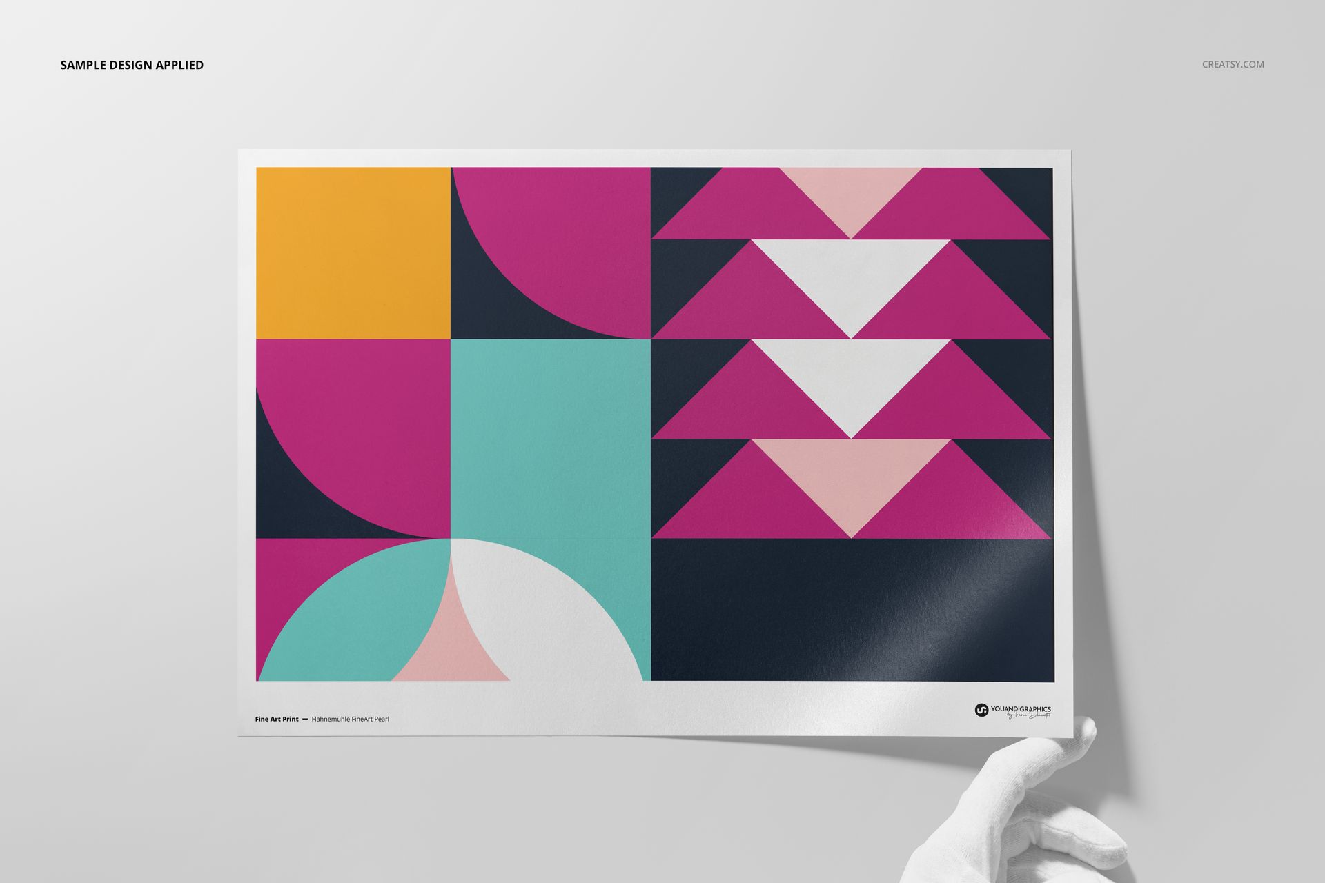 Front view of a Hahnemühle Fine Art Pearl print mockup with bold geometric patterns in vibrant colors, held by a gloved hand.