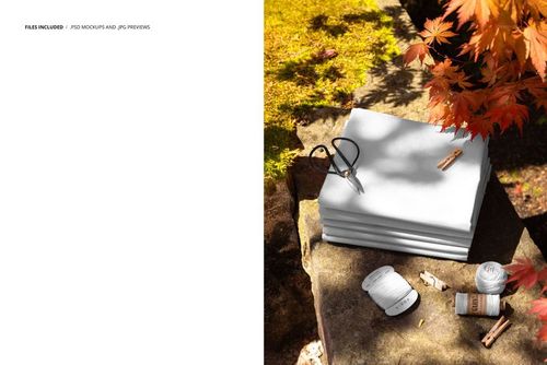 PSD mockup showing folded fabric swatches on a stone ledge, accompanied by autumn leaves and sewing supplies.