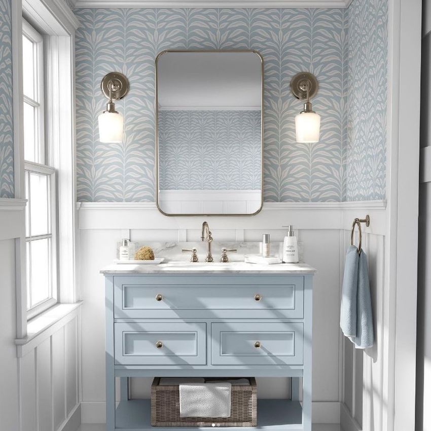 Bathroom mockup featuring a light blue vanity with a marble countertop, wall-mounted mirror, and patterned wallpaper with leaf motifs.