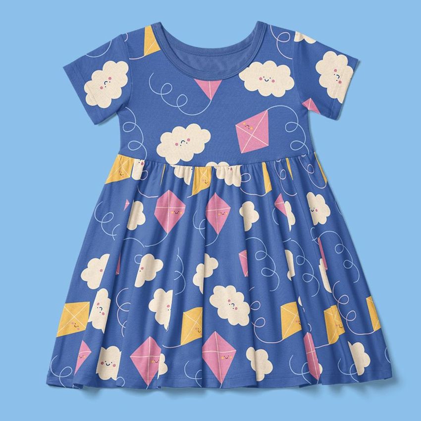 Toddler skater dress mockup featuring a playful clouds and kites pattern in white, pink, and yellow on a blue background.