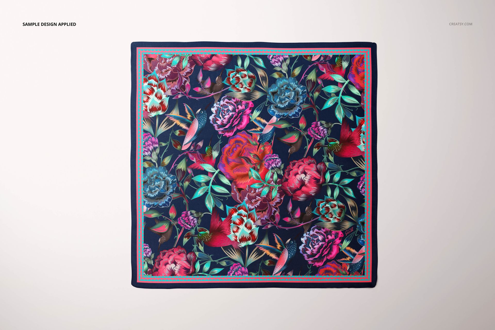 PSD mockup of a square silk scarf with multicolored floral and bird designs, presented on a plain surface.