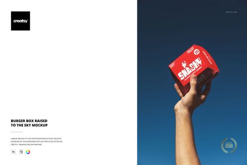 Hand holding a red burger box mockup against clear blue sky, box features bold white text and graphics.