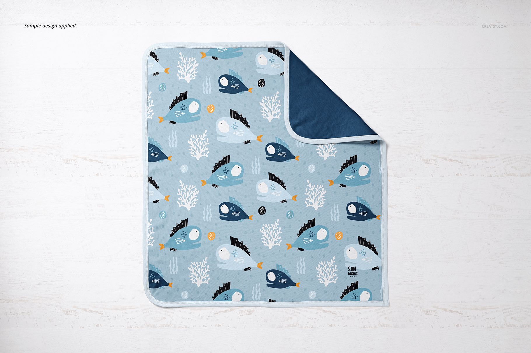 Top view of a cotton baby blanket mockup featuring sea creatures and coral designs in shades of blue and white.