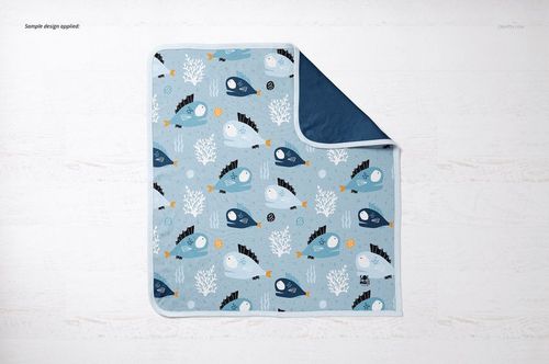 Top view of a cotton baby blanket mockup featuring sea creatures and coral designs in shades of blue and white.