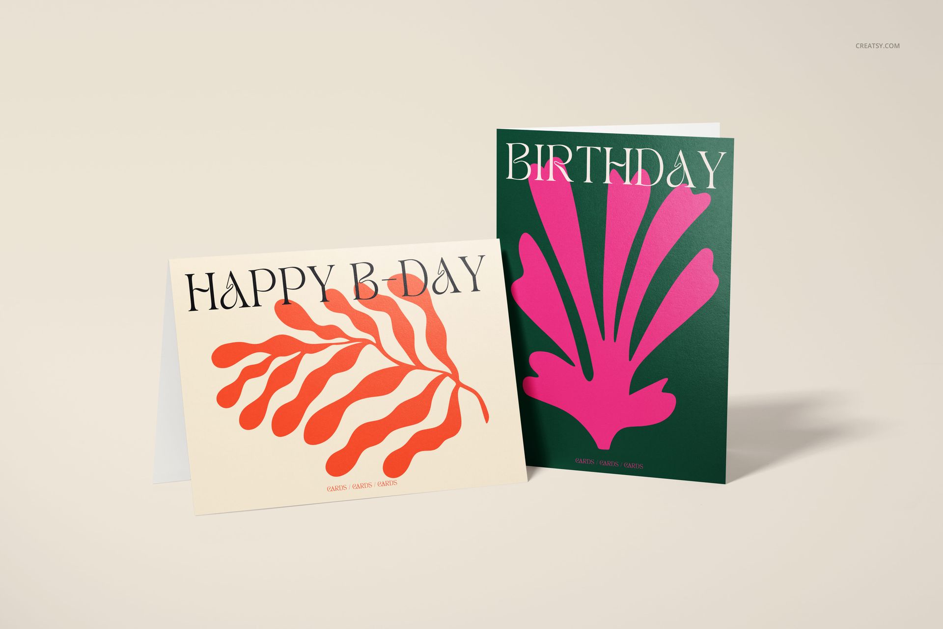 Greeting card mockup set featuring a cream card with orange leaf pattern and a green card with pink abstract design, front view.