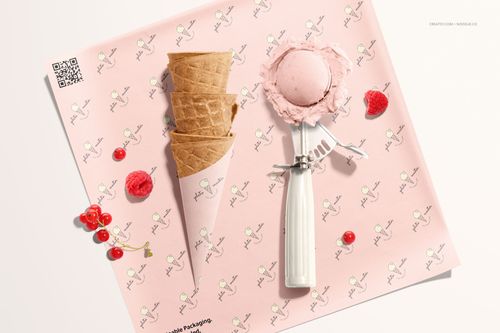 Top view of a mockup featuring a waffle ice cream cone, scoop, and pink food safe paper with small designs.