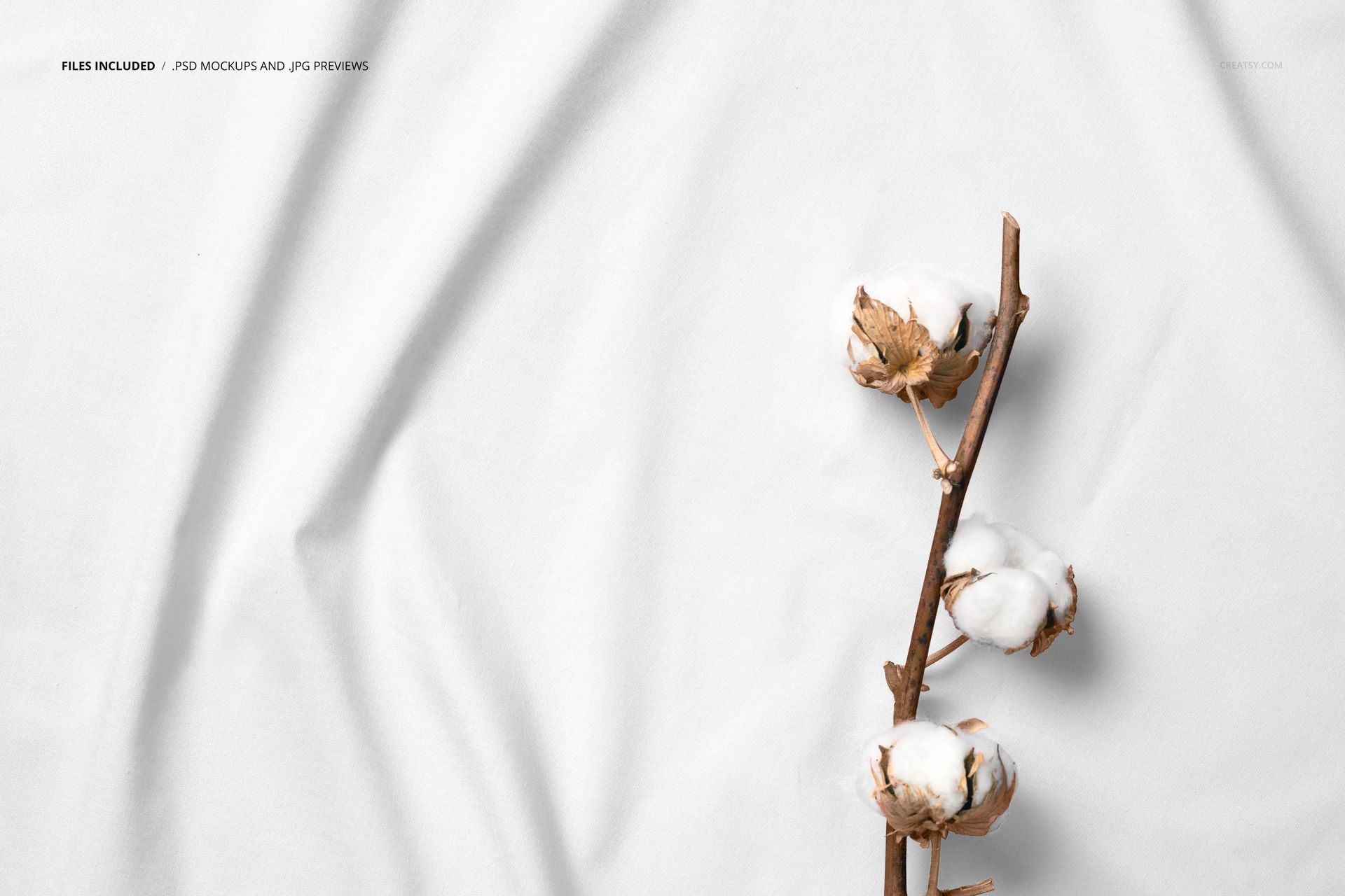 White fabric mockup featuring a cotton branch with fluffy white buds, viewed from above with gentle creases.