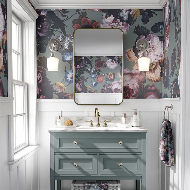 Bathroom mockup featuring a floral wallpaper, rectangular mirror, brass fixtures, and a blue vanity with marble countertop.