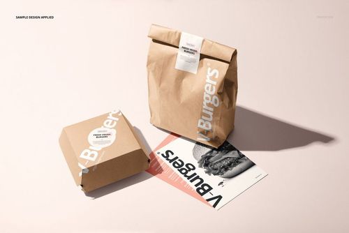 Front view of fast food packaging mockup featuring a brown paper burger box, paper bag, and printed menu on a light surface.