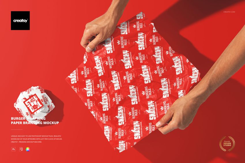 Top view of a person unfolding a red and white patterned burger wrapping paper mockup on a bright red background.