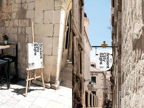 Two Mediterranean city signs mockups, one displayed on an easel outdoors and another hanging above a narrow stone street.