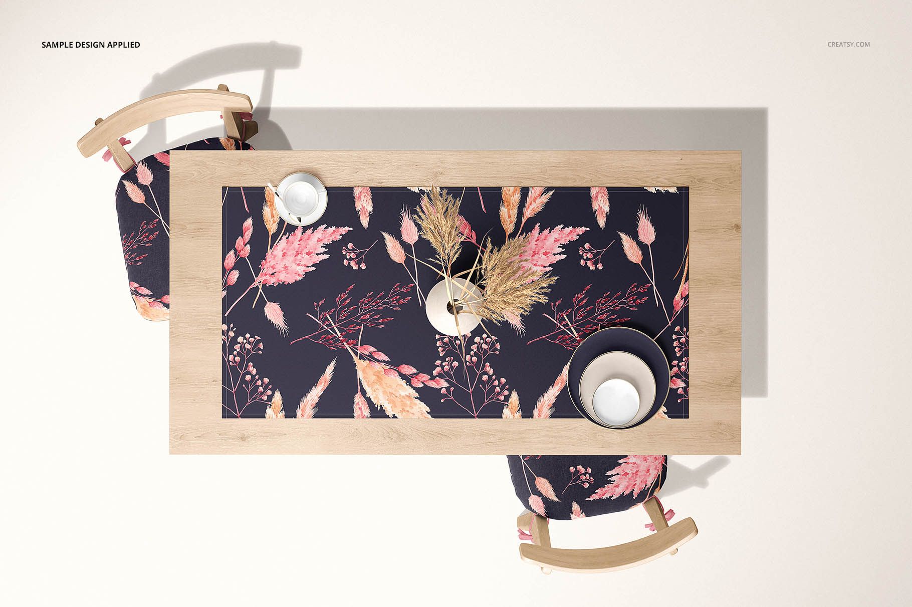 Rectangular table runner mockup featuring a floral design in pastel tones, displayed on a light wood table with two chairs.