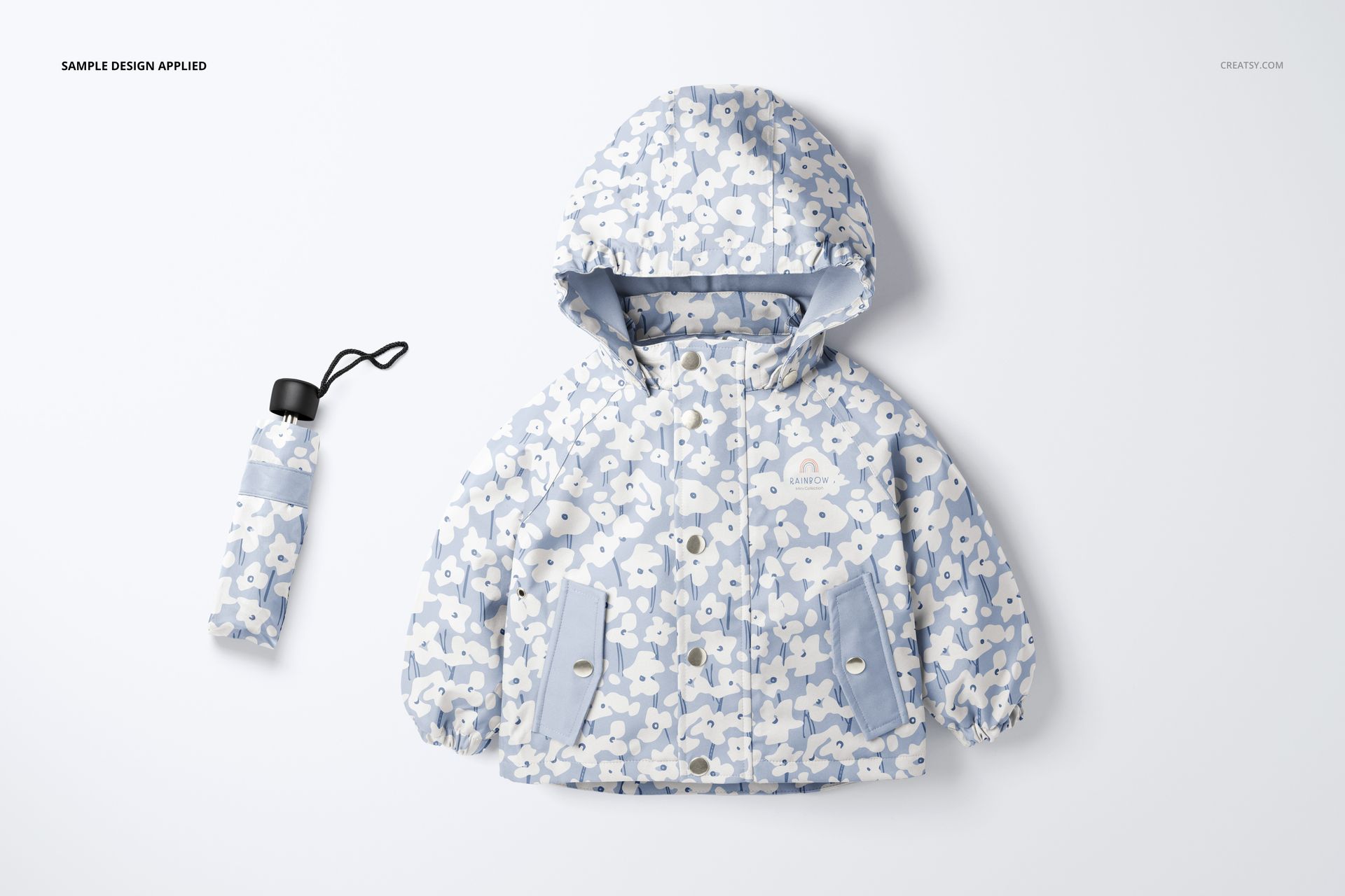 Front view of a kids rain jacket and matching umbrella mockup, both featuring a light blue and white floral pattern on a plain background.