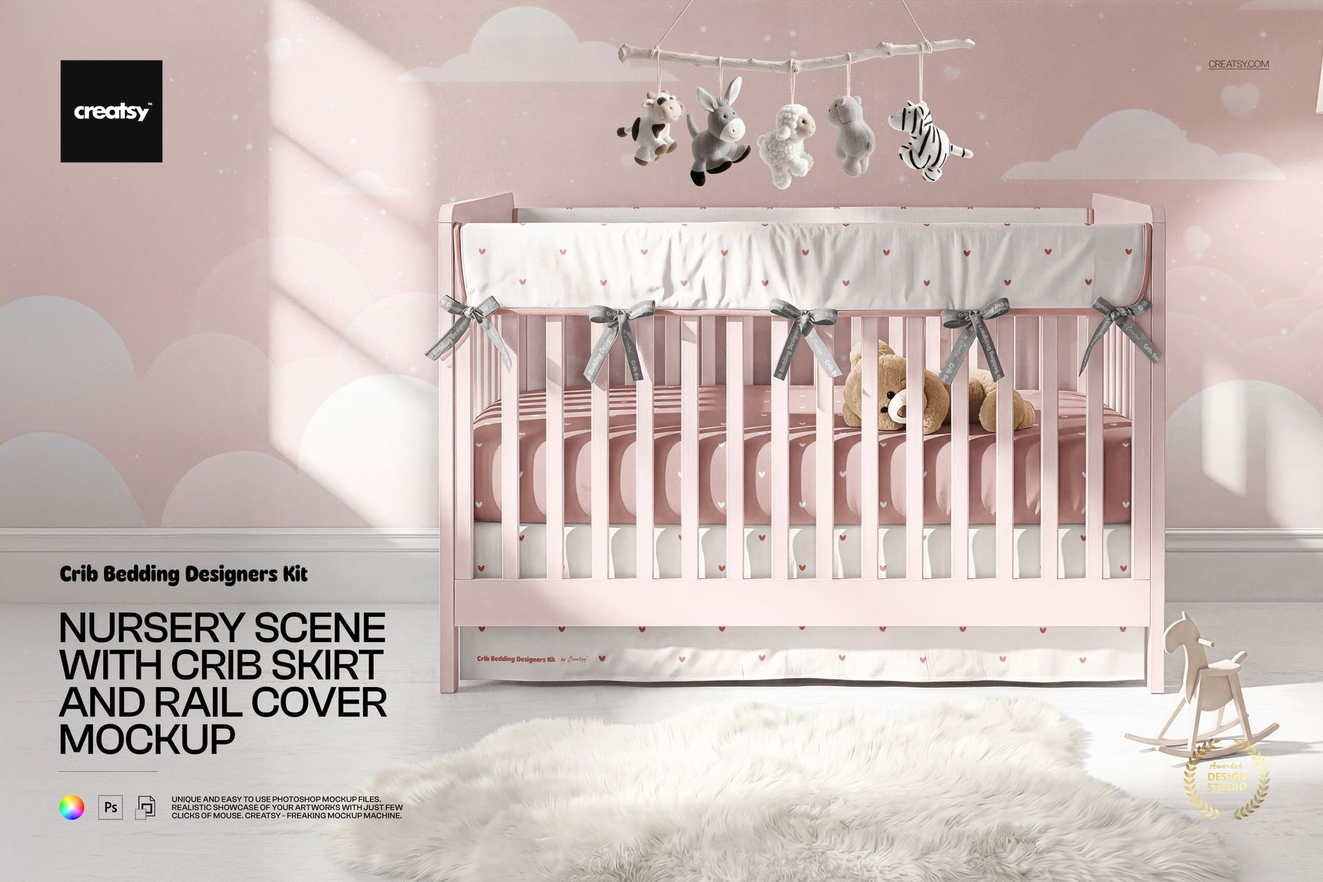 PSD mockup of a nursery setup with a pink crib, white crib skirt, rail cover, hanging mobile, and stuffed toys.