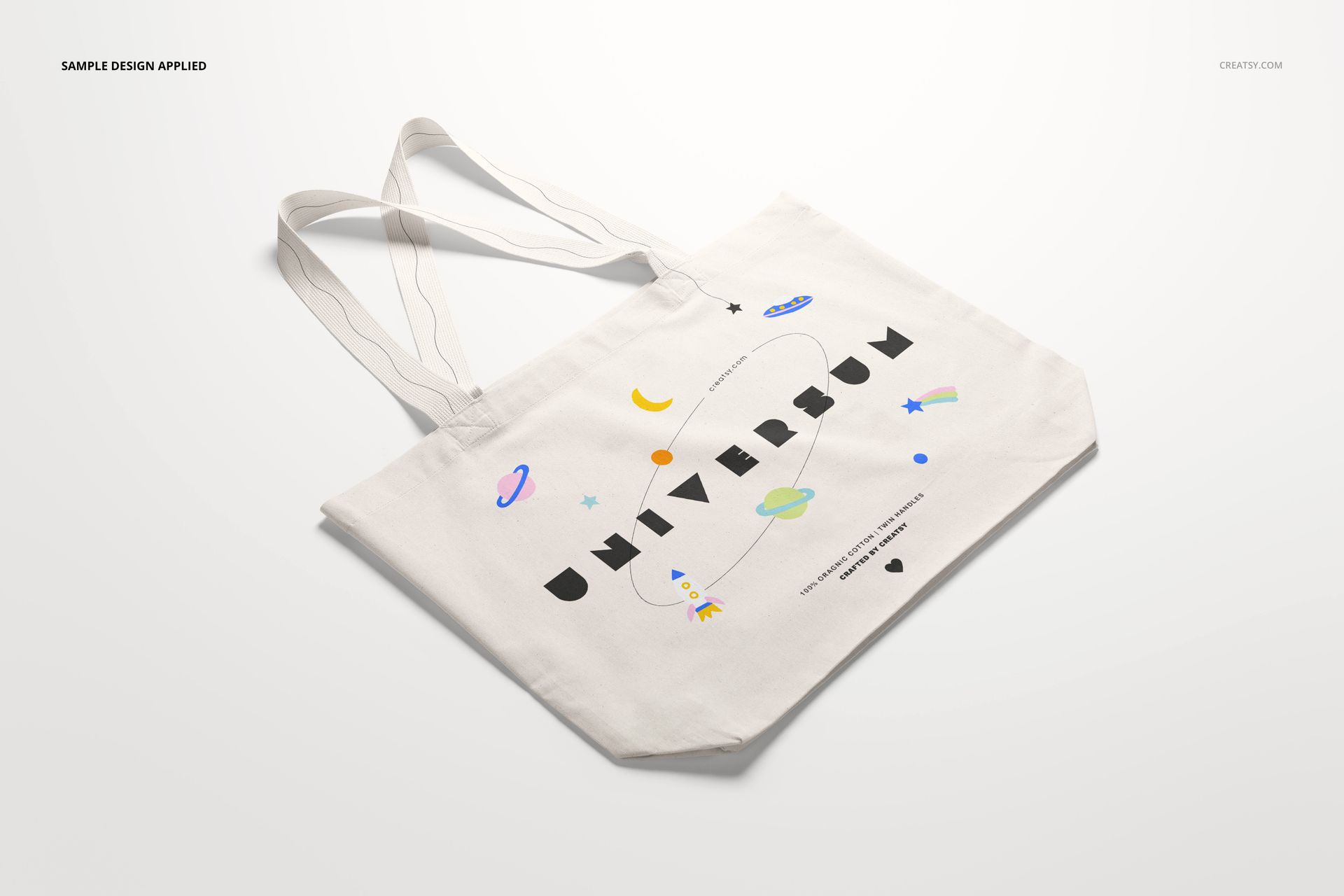 Weekender tote bag mockup displayed at an angle, showing a white bag with colorful space illustrations and bold lettering.