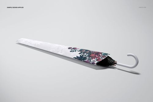 Umbrella packaging mockup showing a closed umbrella with floral accents, angled on a plain, light surface.