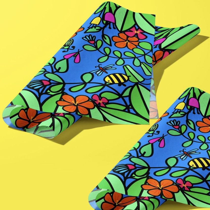 Angled folded tissue paper packaging mockup featuring a vibrant garden-themed pattern with flowers, leaves, and bees on a blue background.
