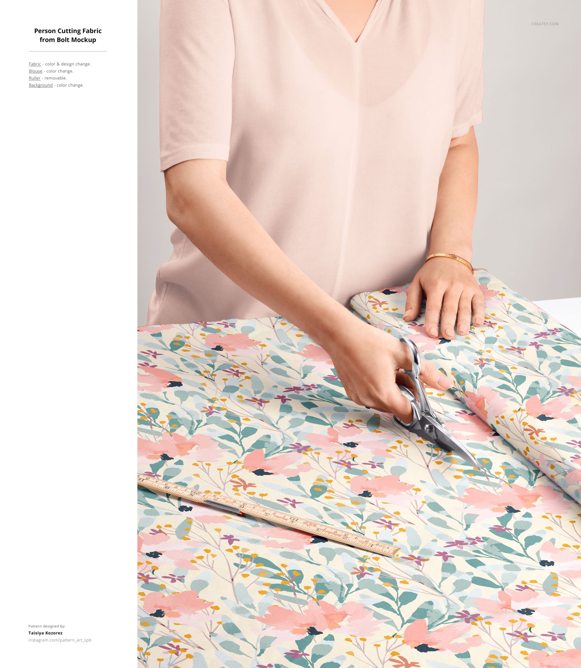 Cotton fabric with colorful flower design being trimmed with scissors, close-up of workspace in a fabric mockup.