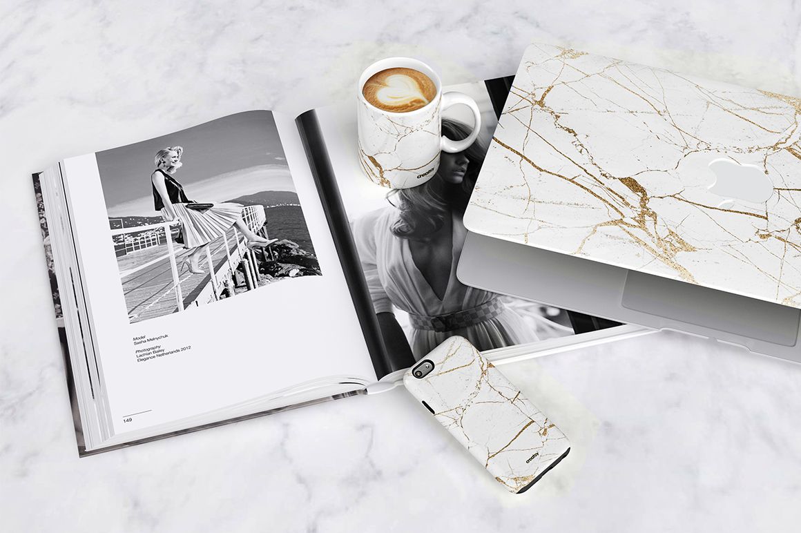 PSD mockup scene featuring a marble design mug, laptop case, and phone case on a marble background.