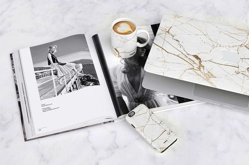 PSD mockup scene featuring a marble design mug, laptop case, and phone case on a marble background.