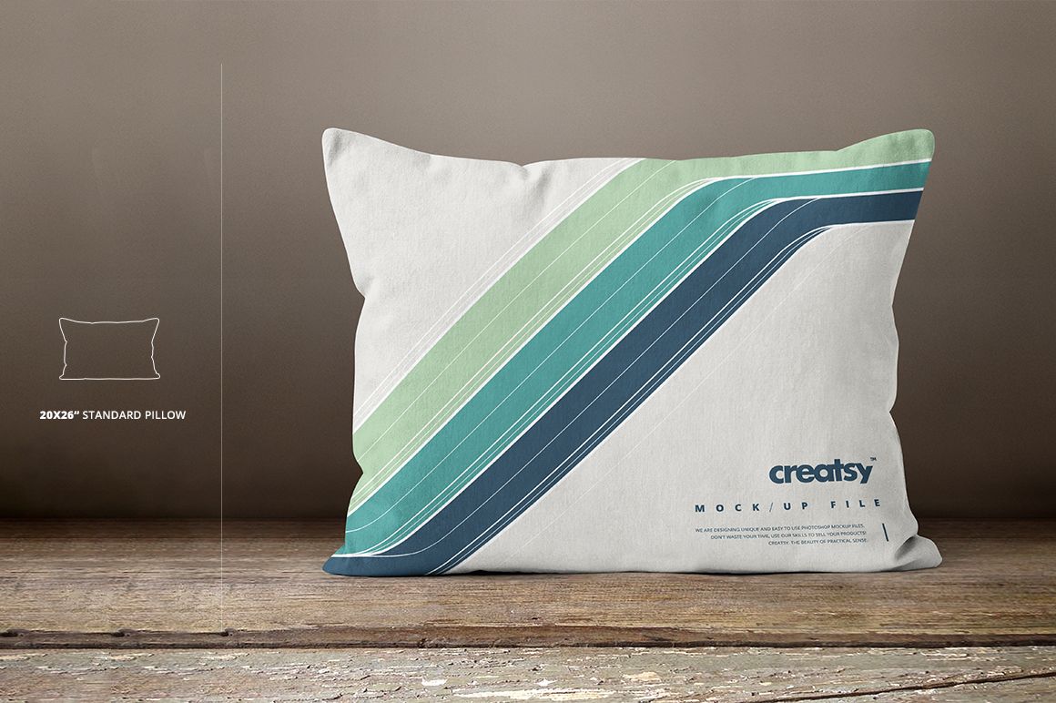 Standard rectangular pillow mockup with diagonal blue and green stripes on a white background, front view on wooden surface.