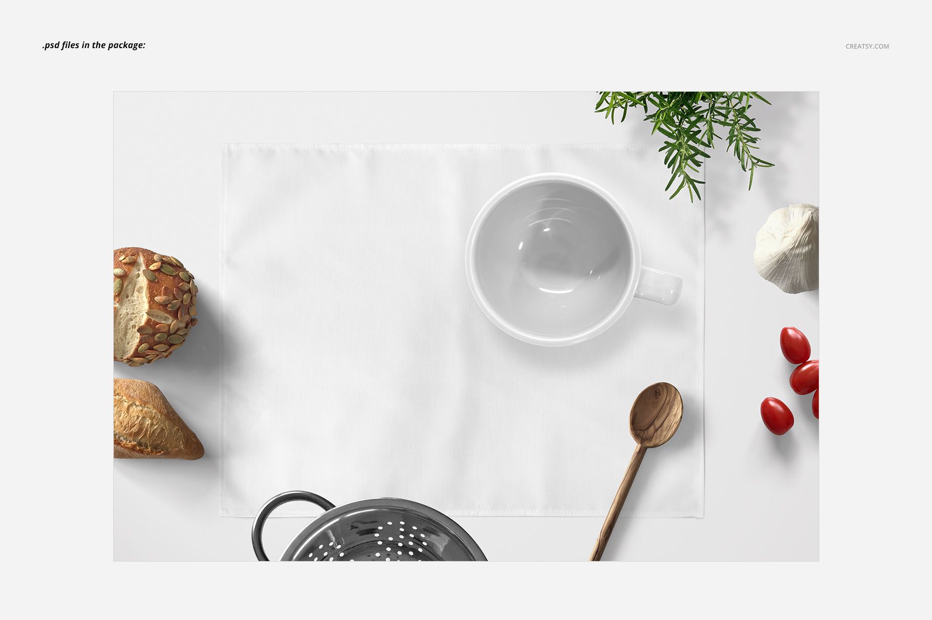 White placemat mockup displayed from a top view, surrounded by bread, tomatoes, herbs, a wooden spoon, and a white bowl.