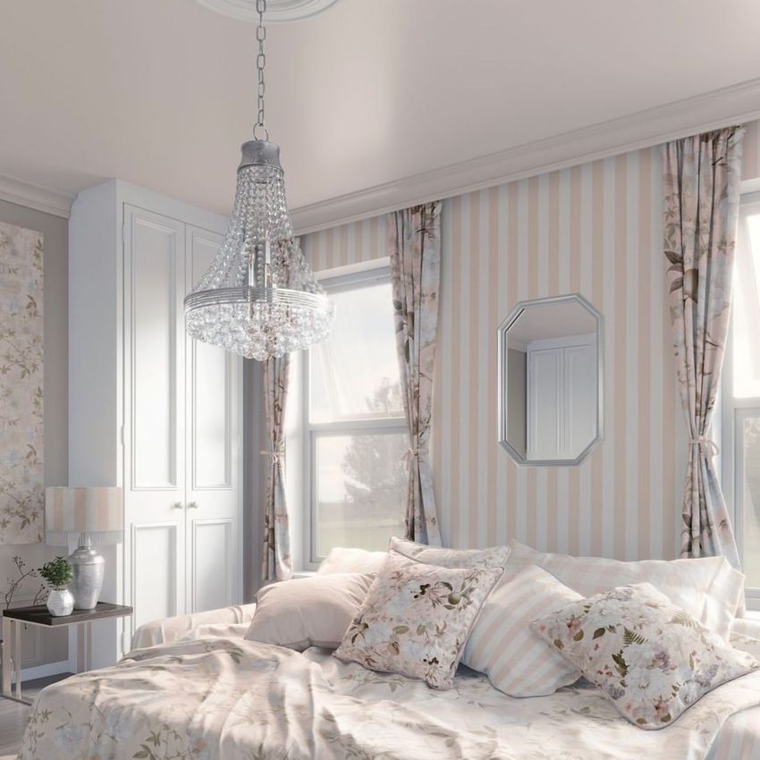 Bedroom mockup with a bed covered in floral and striped pillows, striped wallpaper, floral curtains, and a crystal chandelier.