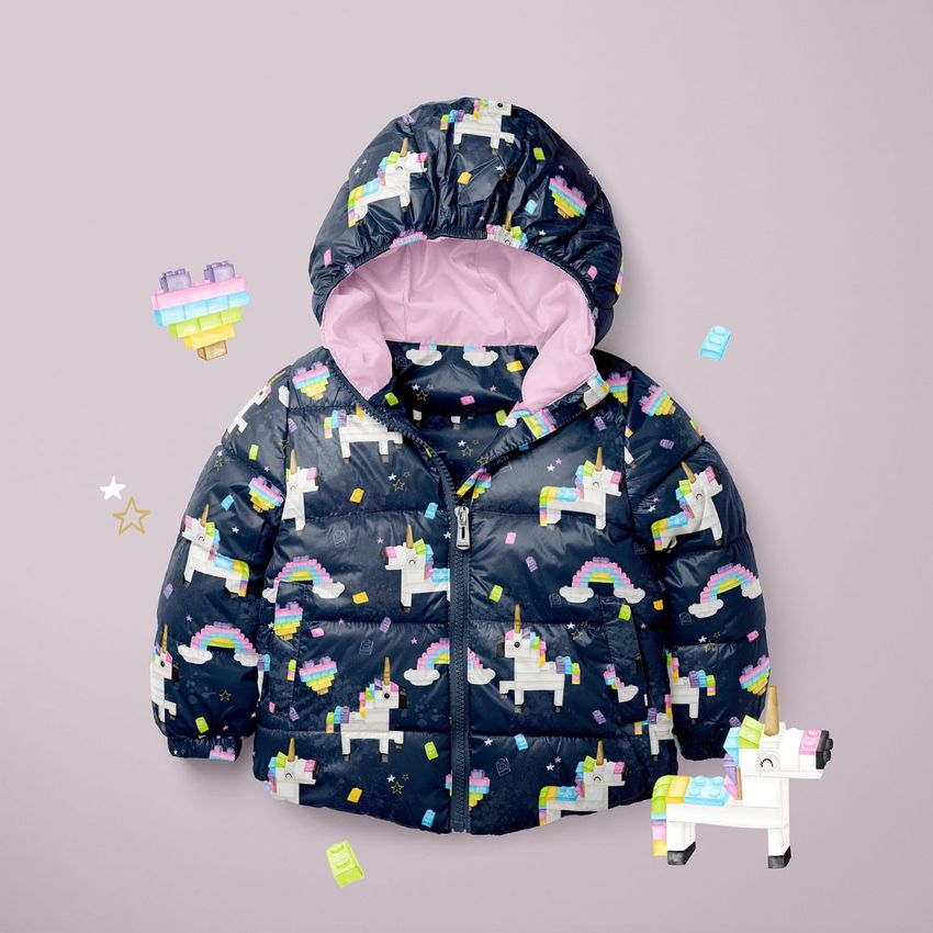 Kids winter set mockup featuring a navy blue puffer jacket with unicorn and rainbow patterns, displayed on a light purple background.