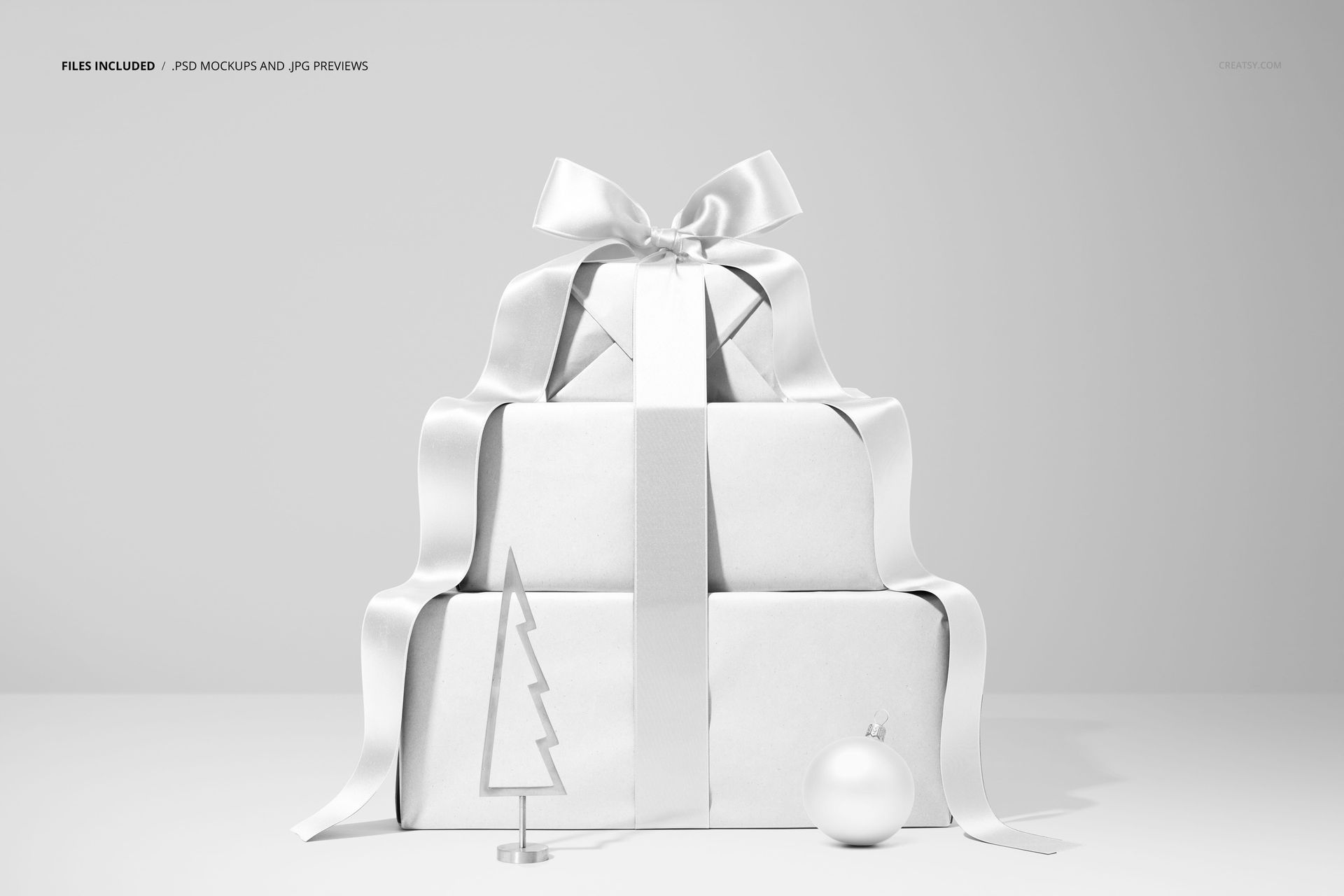 PSD mockup featuring a stack of holiday gift boxes tied with a large ribbon, next to a small tree ornament and round bauble.