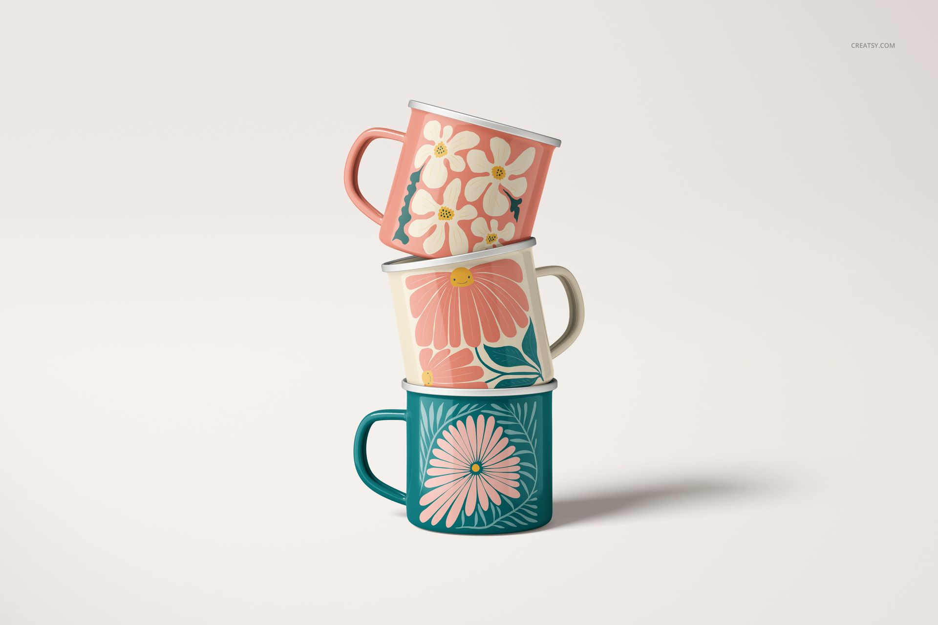 PSD mockup set showing enamel mugs with floral artwork, viewed from the front against a neutral backdrop.