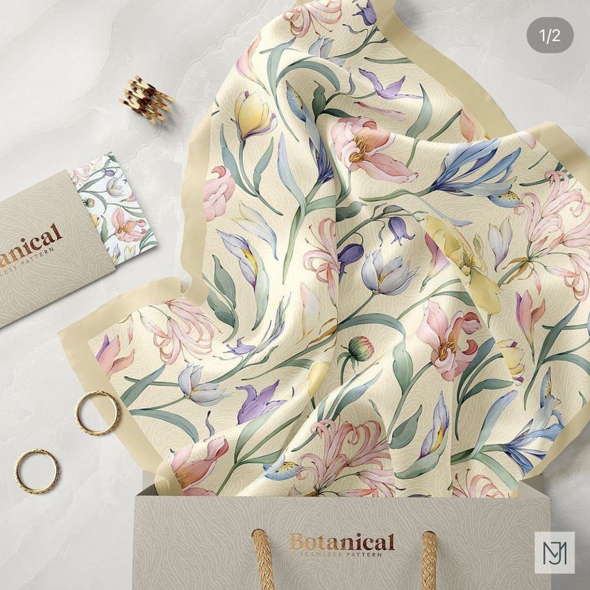 Silk scarf mockup featuring a floral botanical pattern in soft pastel colors, draped over a marble surface with a shopping bag and jewelry props.