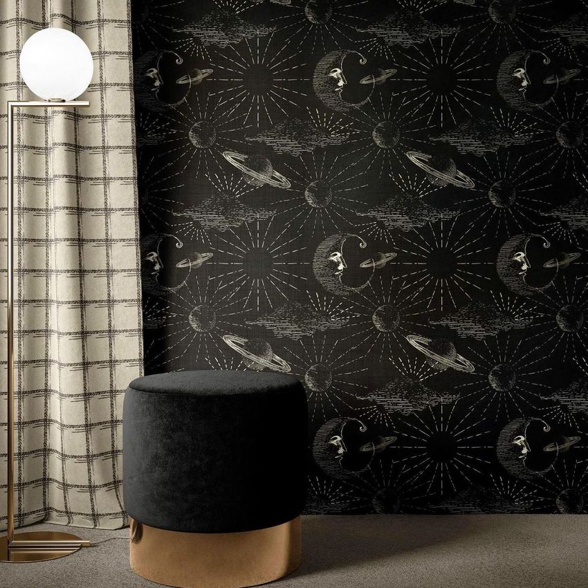 Interior scene mockup showing a black wall with celestial patterns, a round black ottoman with a gold base, a floor lamp, and a plaid curtain.