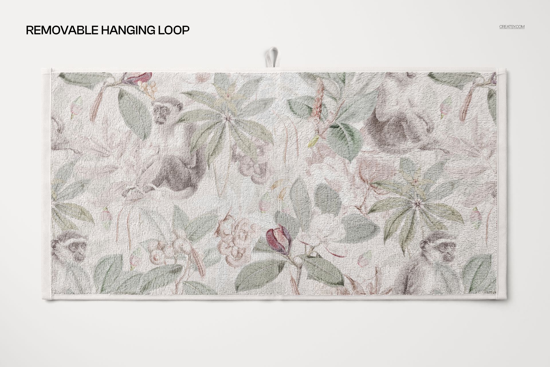 Bathroom towel mockup featuring a light-colored floral and animal design, displayed with a removable hanging loop.