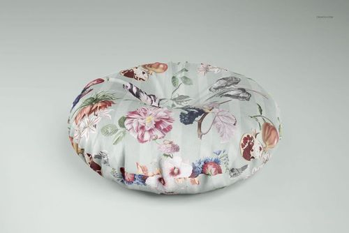 PSD mockup of a circular floor pillow with multicolored flowers and leaves, presented from a front perspective.