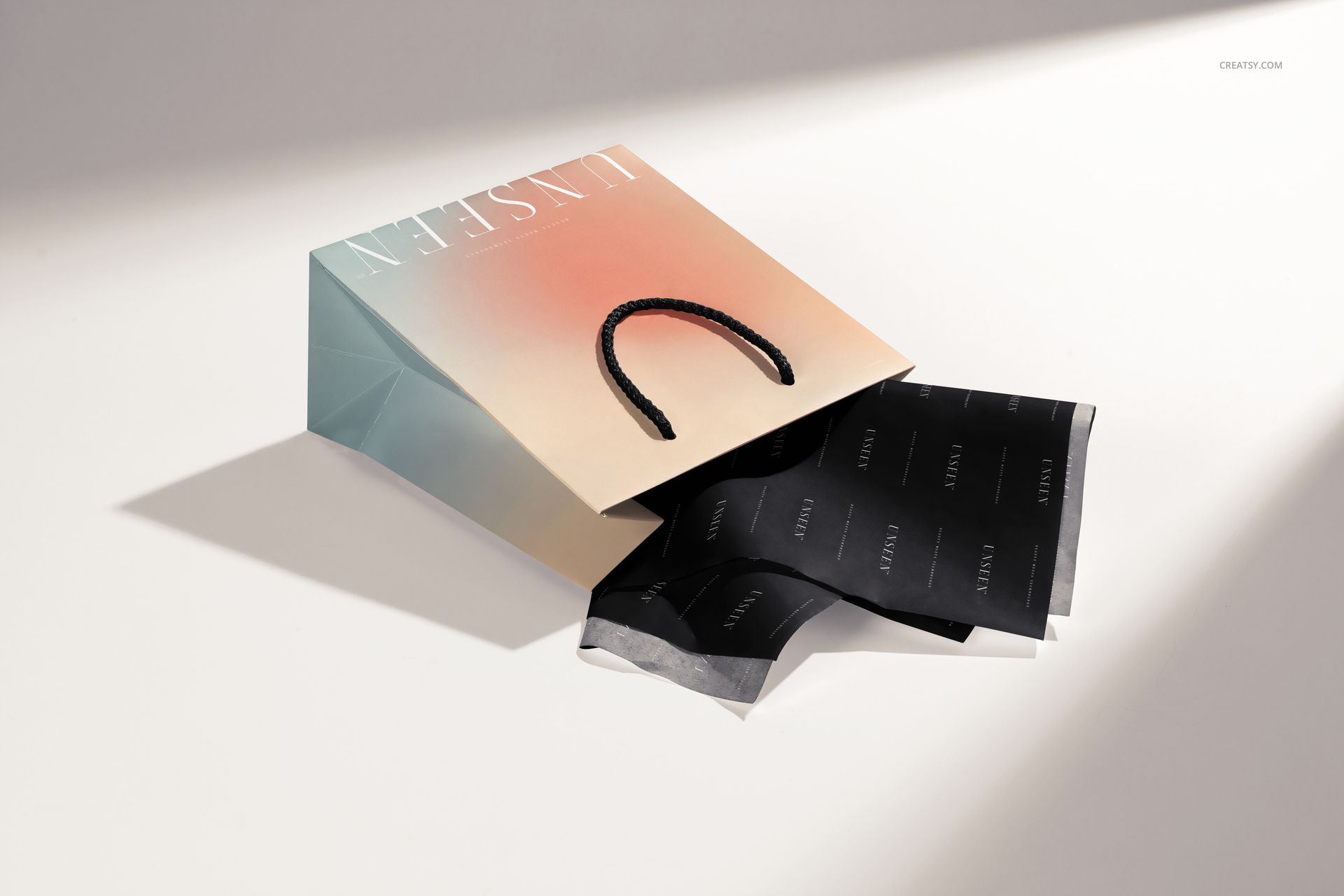 Mockup of a rectangular gift bag with a pastel gradient design and black tissue paper, displayed on a light background.
