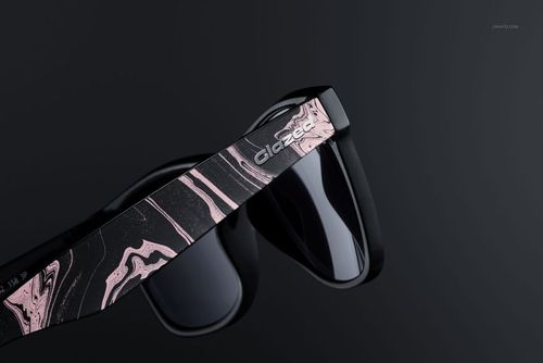 Close-up of custom printed sunglasses mockup with black frames and pink marble design on the arms against dark background.