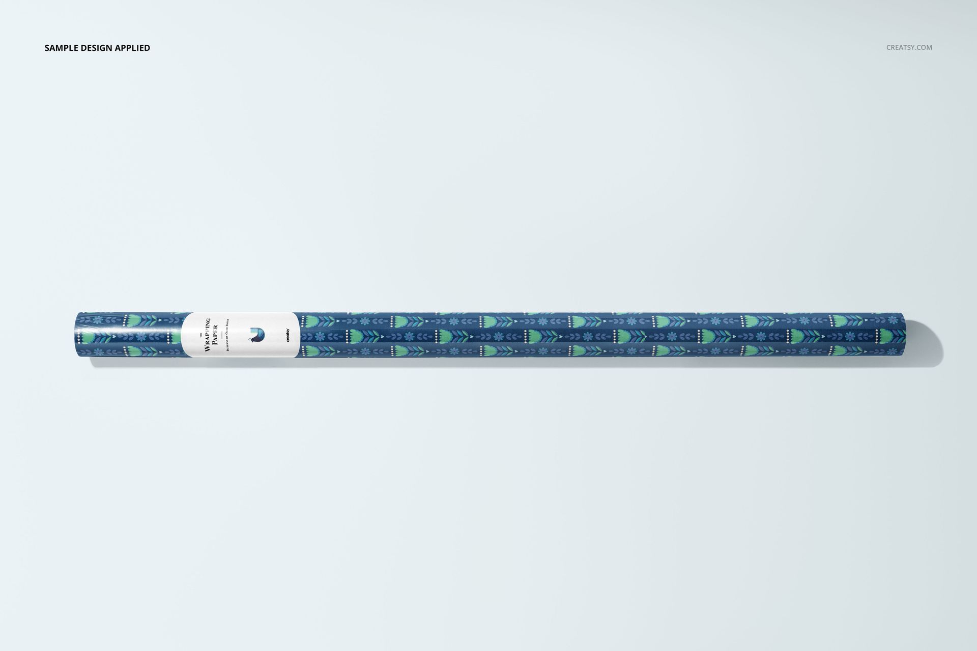 Gift wrapping paper PSD mockup roll with a decorative blue and green motif, displayed from a bird’s-eye perspective.