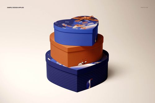 Heart-shaped chocolate box mockup with two stacked boxes, blue and orange colors, and playful graphic designs on lids.