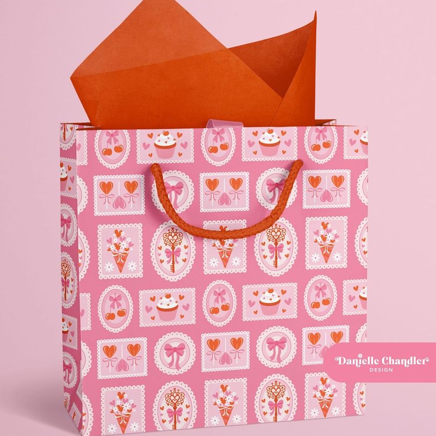 Jewelry box and bag mockup featuring a pink gift bag with red handles and patterned wrapping tissue paper on a pink background.