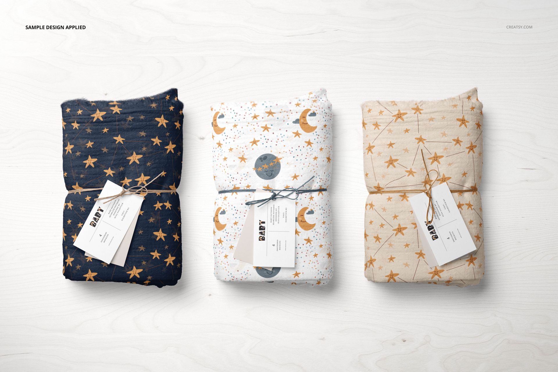 Muslin swaddle blanket PSD mockup showing three blankets in blue, white, and beige with star and moon motifs, arranged side by side.