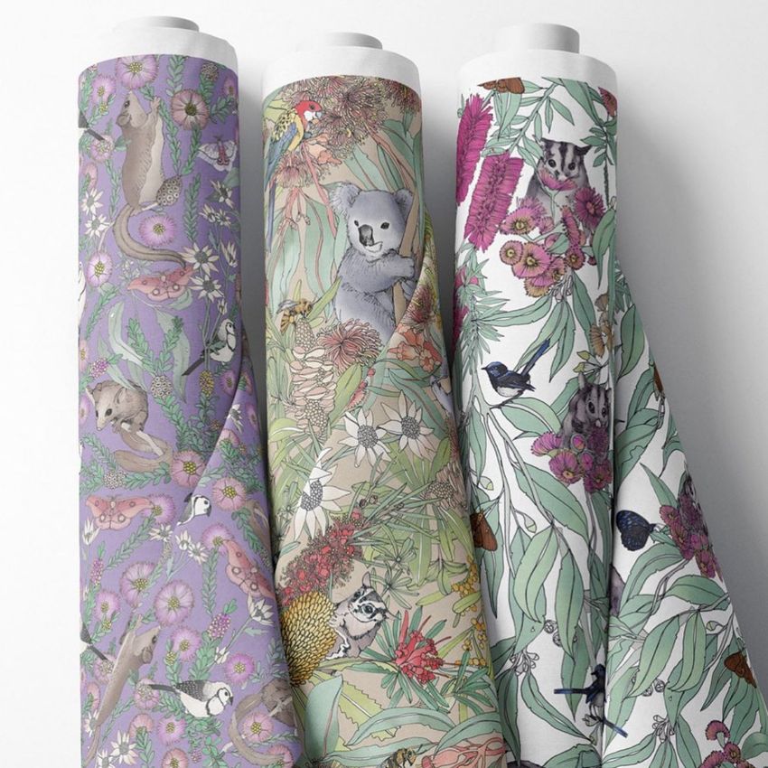 Fabric rolls mockup showing three upright rolls with detailed botanical and animal patterns in pastel and natural colors.