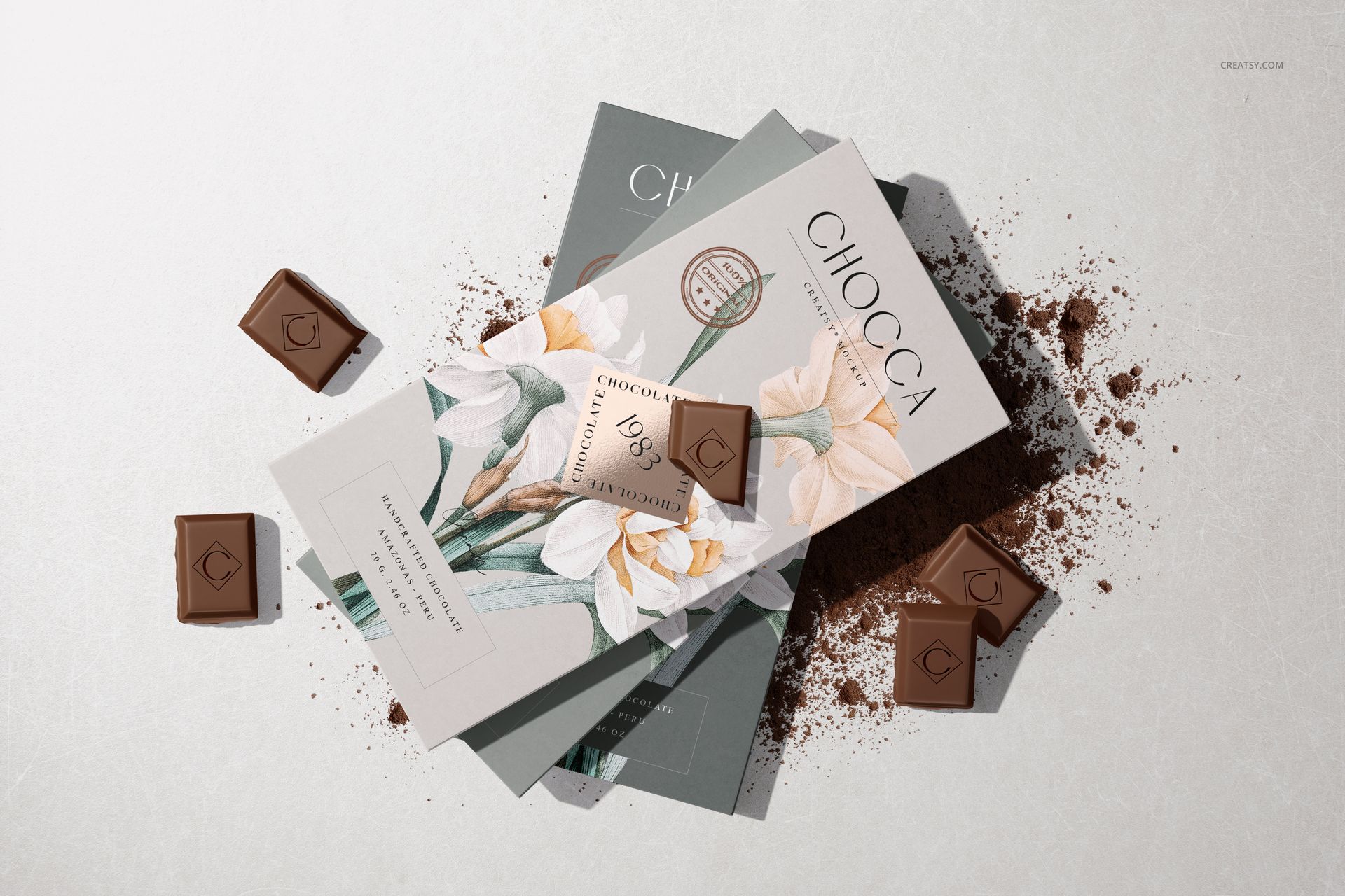 Chocolate bar packaging mockup featuring elegant floral wrappers, chocolate pieces, and cocoa powder on a neutral background.