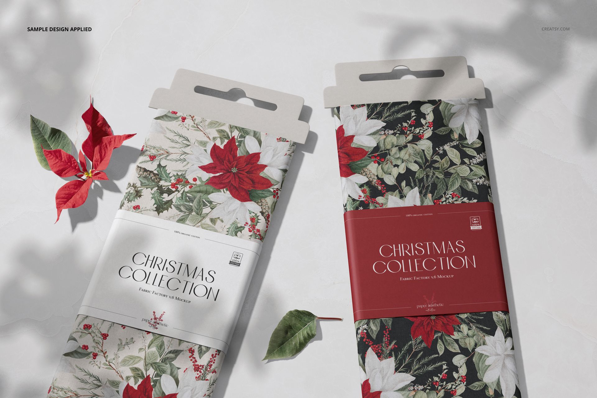 Front view of two fabric bolts mockup featuring festive floral designs, packaging labels, and scattered leaves.