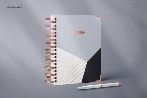 Front view of a wire-bound planner mockup featuring a modern cover pattern and copper spiral binding on a gray surface.