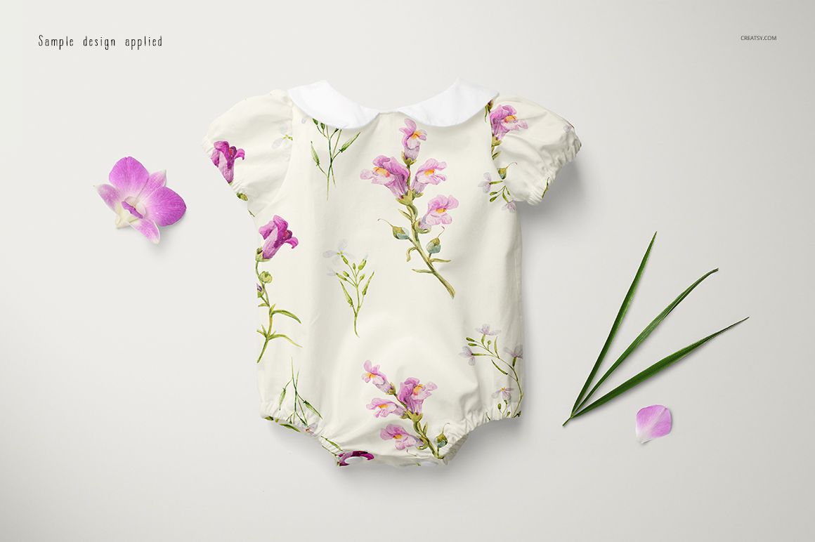 Front view of a baby romper mockup with short sleeves, featuring a floral pattern on a light background, surrounded by orchid flowers and green leaves.