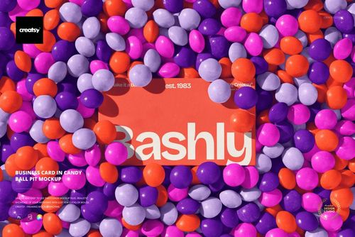 Rectangular business card mockup lying flat in a colorful candy ball pit with purple, orange, and white balls.