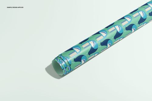 PSD mockup of a rolled wrapping paper with playful blue whale illustrations, presented on a soft, light-colored surface.